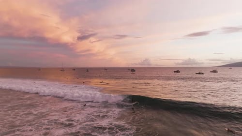 Surfer catching an epic wave in Hawaii during sunset.