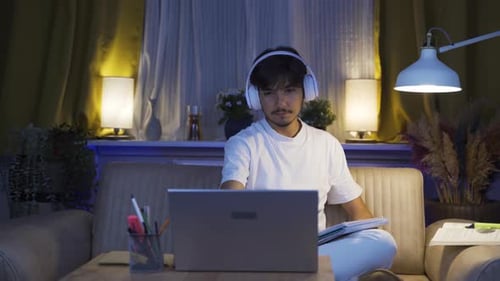 Man with Headphones Working at Home at Night