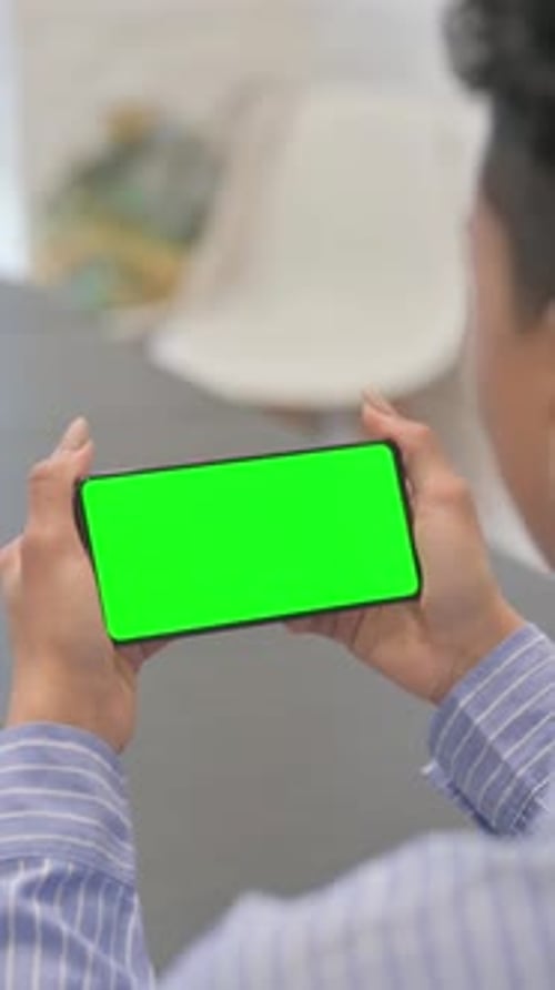 African Woman Holding Horizontal Green Screen Smartphone, vertical video