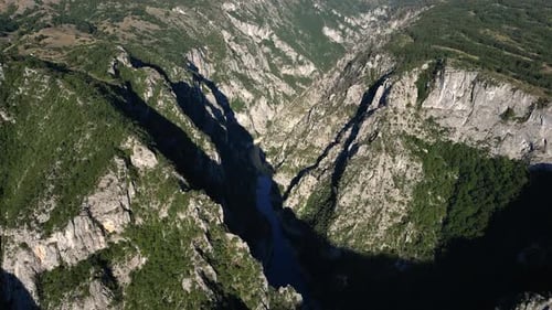 Ein gewundener Fluss fließt am Grund einer epischen Schlucht. Luftbild.