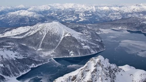 Partially Frozen Mountain Lake and Winter Mountainous Landscape AERIAL