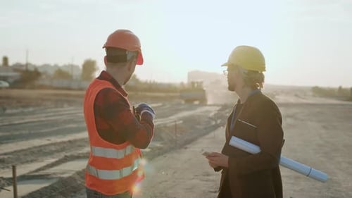 Construction Workers Discussing Building Plans at Site