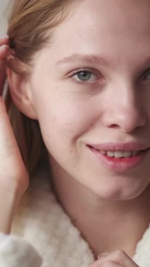 Woman Applying Cream to Face and Smiling