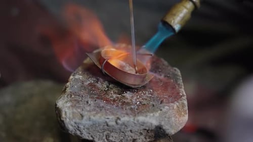 Craftsman Soldering the Tip of the Scabbard in the Workshop