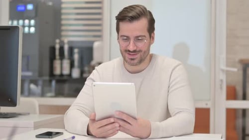Young Man Doing Video Chat on Tablet in Office
