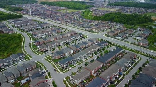 Aerial view of suburban neighbourhood flying backwards away from houses