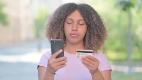 Outdoor Portrait of African Woman Excited for Online Shopping on Phone