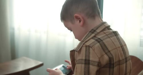 Boy Uses Handheld Device Indoors