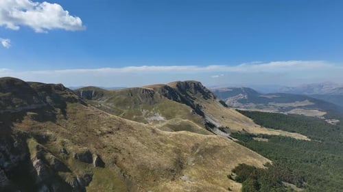 Flight over beautiful mountain peaks covered with grass. Mountain from above on a sunny autumn day.