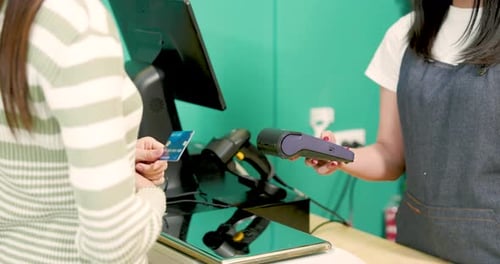 Customer Swiping Credit Card at POS Terminal