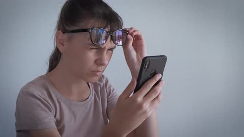 Young Adult Using Smartphone, Wearing Glasses