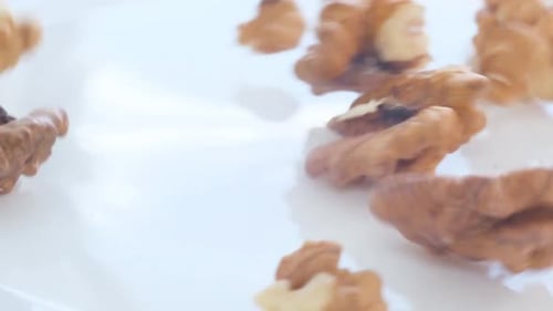 Walnut pieces fall onto a white surface