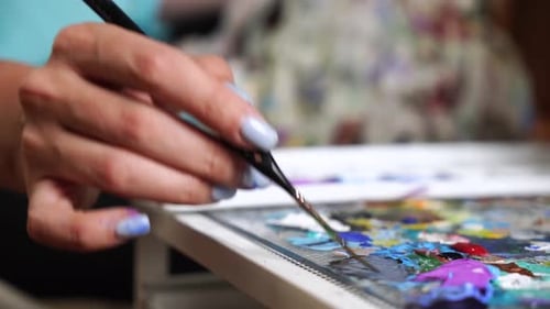 Woman Artist Expressing on Canvas in Studio, close-up