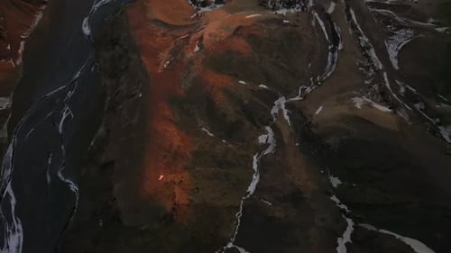 Top down sunrise in Iceland, vast mountain hill panorama with snow and rivers