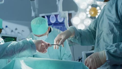 Nahaufnahme im Operationssaal, Assistent verteilt Instrumente an Chirurgen während der Operation.