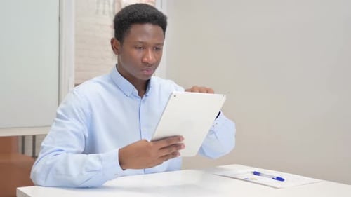 African Businessman Using Digital Tablet in Office