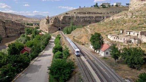 Aerial view railbus leaves the tunnel and enters the station in the town 4k