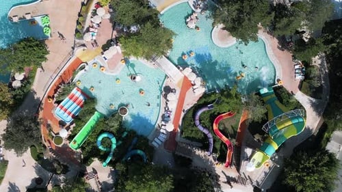 Aerial Drone View of a Colorful Water Park Filled with Winding Slides Pools and Lazy Rivers