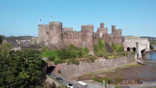 Aerial perspective of a medieval castle and suspension bridge in Conwy, Wales.
