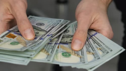 Closeup of Male Hands Counting a Stack of US Hundred Dollar Bills