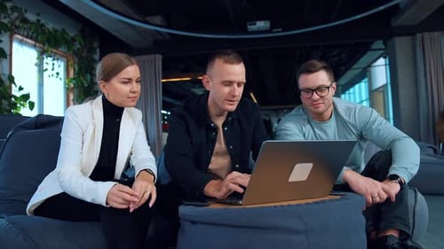 Team Collaborating on Laptop in Modern Office Setting