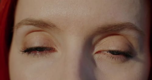 Closeup Slow Motion Portrait of Beautiful Young Woman's Eyes Looking at Camera Blinking