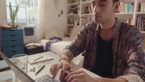 Young Adult Using Laptop at Desk Indoors