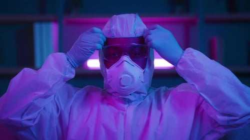 Young Adult Removing Protective Gear Indoors at Night