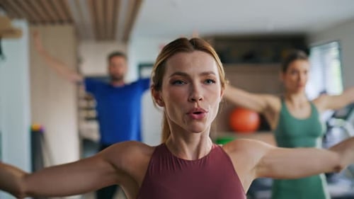 Grupo de jóvenes entrenando ejercicios deportivos en el gimnasio Mujer deportista levantando la mano