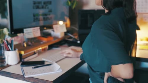 Businesswoman, back pain and stress at night on computer, deadline and muscle ache or injured