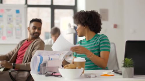 Colleagues working and discussing business in a bright office