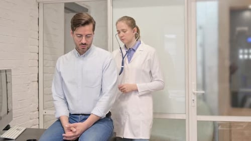 Doctor Examining Patient with Stethoscope in Clinic