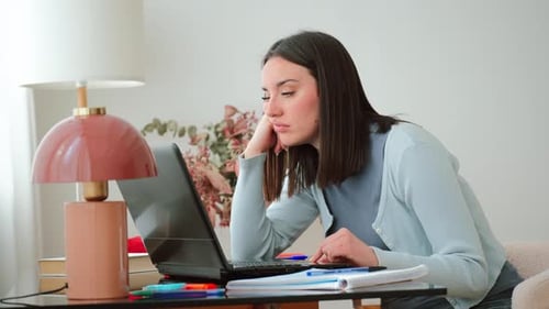 Young Woman Experiencing Stress and Frustration While Focused on Her Laptop and Contemplating Her