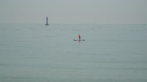 Paddleboarding - Man On Stand Up Paddle Board At Songjeong Beach In Busan, South Korea. - wide shot