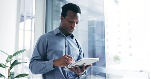 Tablet, thinking and a business black man at a window in his professional office for planning