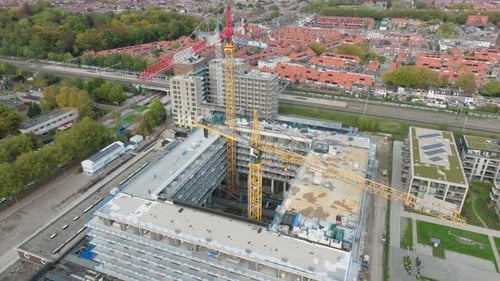 Aerial retreat out of construction site building new apartment for new residents