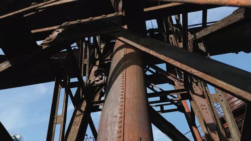 Intricate, rusted exterior of an old industrial structure, featuring a large cylindrical pipesurroun
