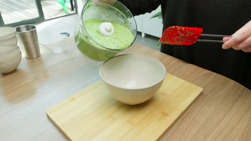 Pouring Green Liquid Into Bowl in Kitchen