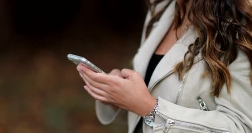 CLose-up woman hands typing on cellphone