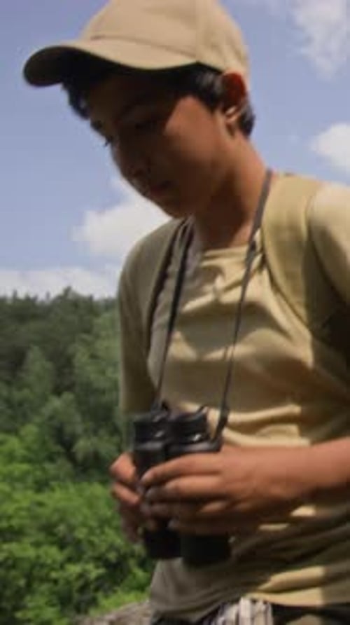 Vertical of Boy with Binoculars and Dad with Backpack Walking Down Hill