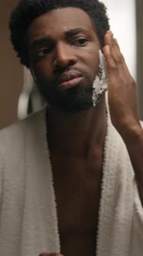 Man Applying Shaving Cream in Bathroom Mirror