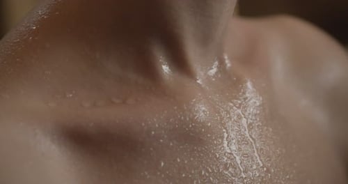 Relaxing young woman in a spa after fitness with water flowing down her skin