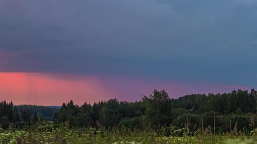 A dramatic lightning and thunderstorm in the dark sky over the forest - time lapse