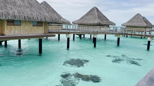 Complejo vacacional de verano en Bora Bora en la Polinesia Francesa con una laguna poco profunda de color turquesa y aguamarina