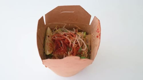 View of a Thailand cuisine Pad Thai dish, a stir-fried rice noodle meal, in a take-out delivery box.