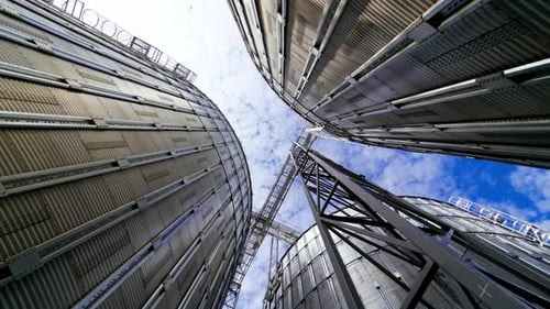 Modern grain terminal. Metal storage tanks for drying grain. Industrial equipment for agribusiness.