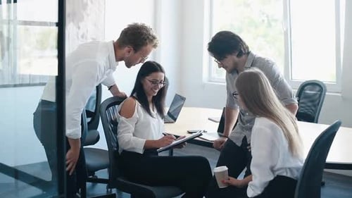Woman signing document. Young business people in formal clothes working in the office