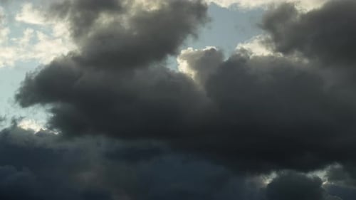 Time lapse of dark clouds moving with blue patches of sky