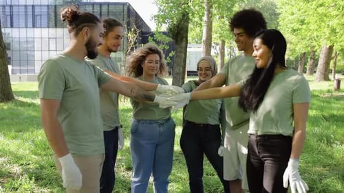 Portrait of multiethnic group of volunteers with garbage bags after cleaning city park.