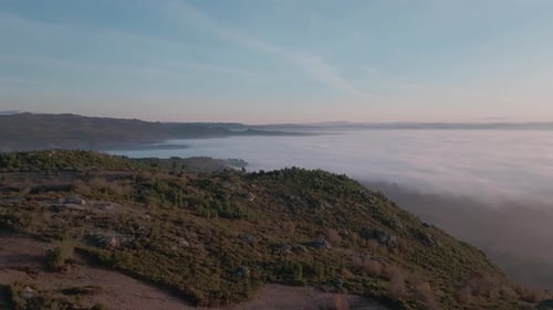 Luftaufnahme eines nebelbedeckten Tals bei Sonnenuntergang Klarer Himmel mit Kondensstreifen